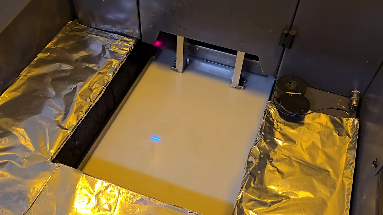 Laser tracing a layer across the resin vat of a UnionTech SLA printer at Rapid3D