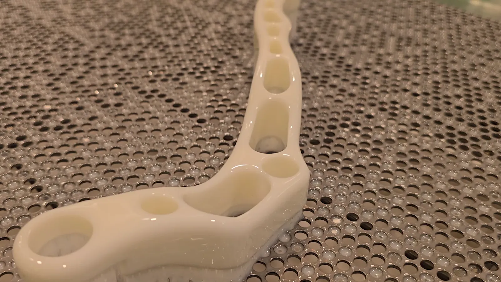 A white SLA part on the build platform of a UnionTech printer at Rapid3D